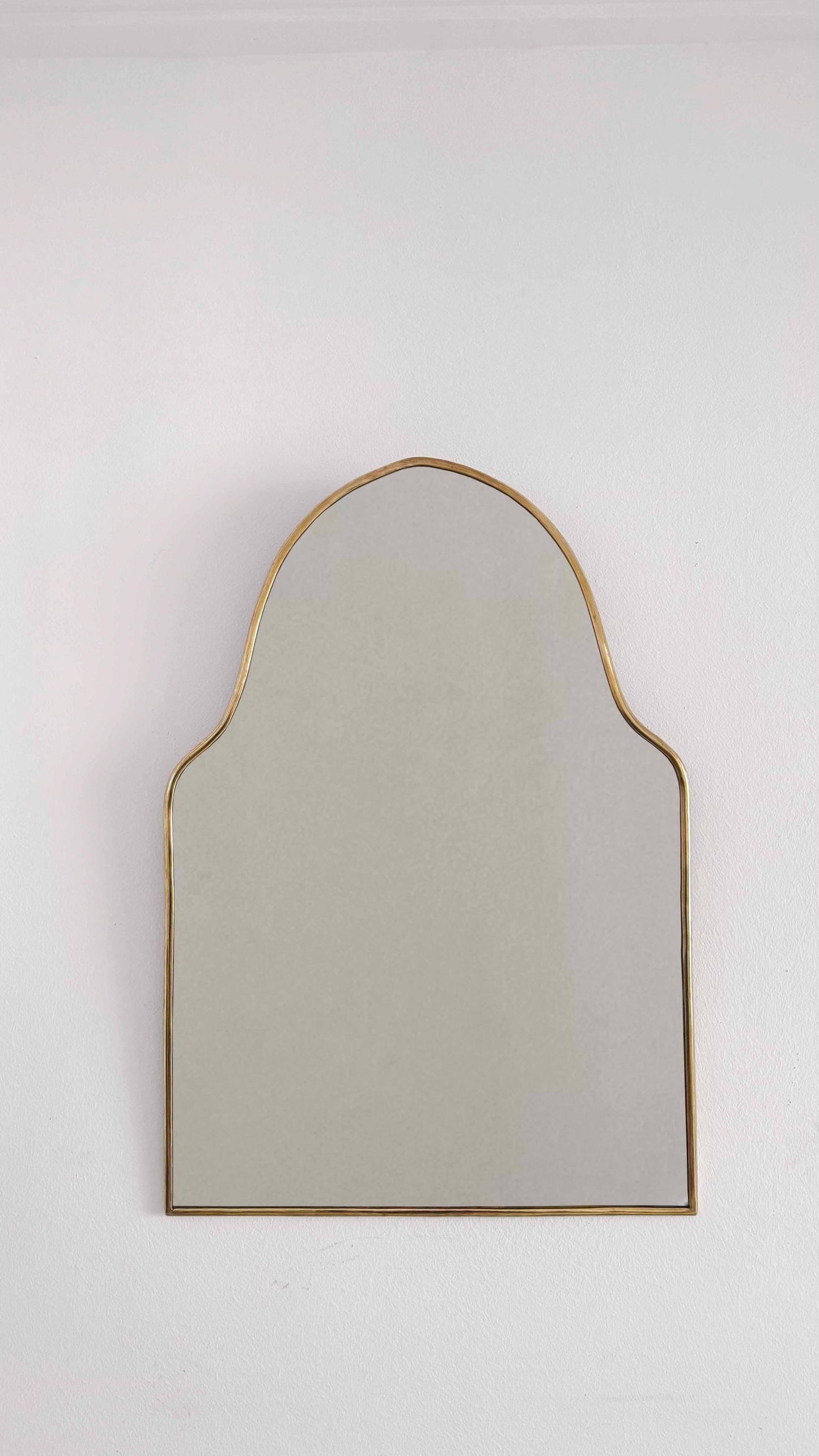 arch brass mirror in white background