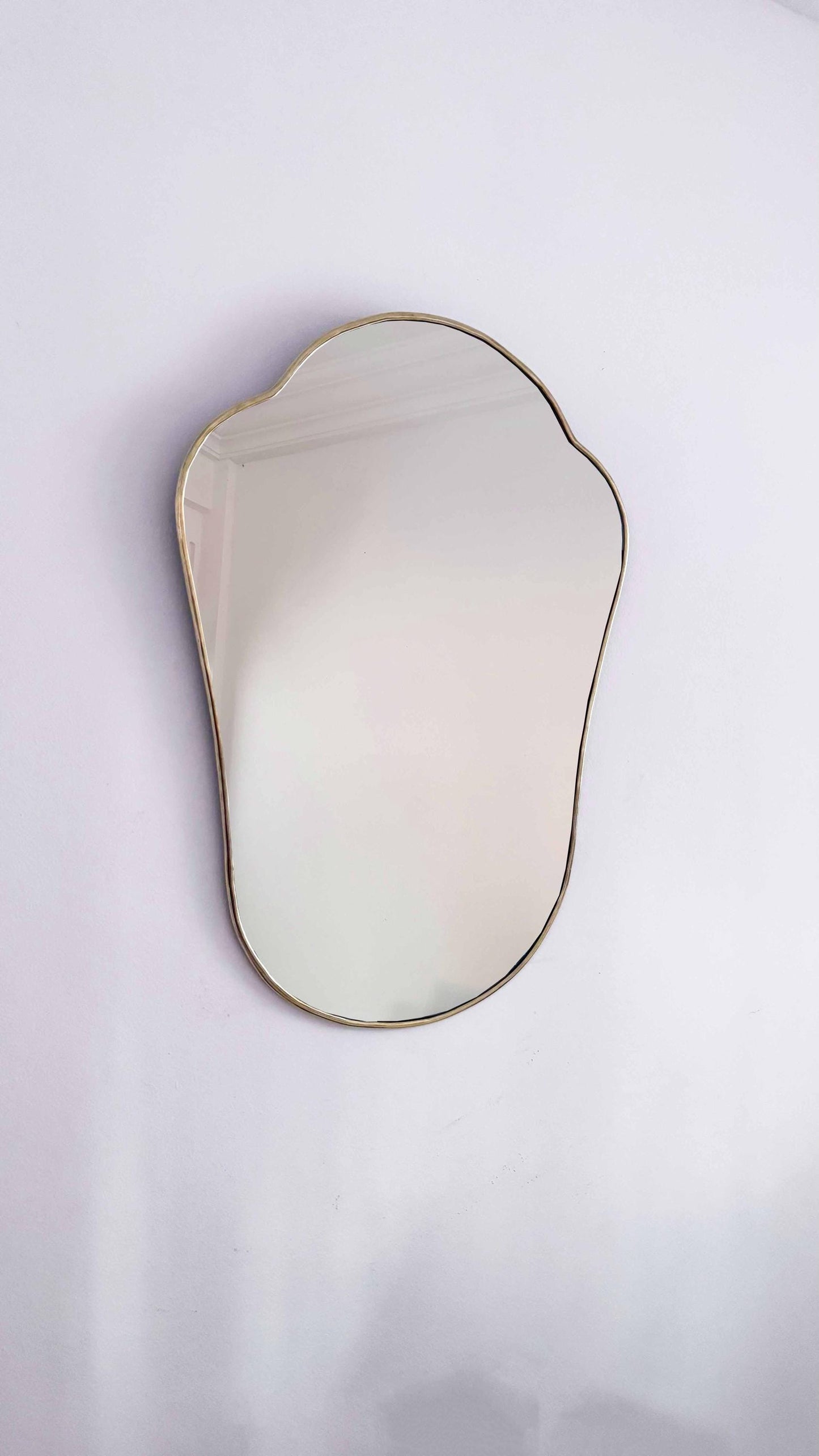 antiqued brass mirror on white wall