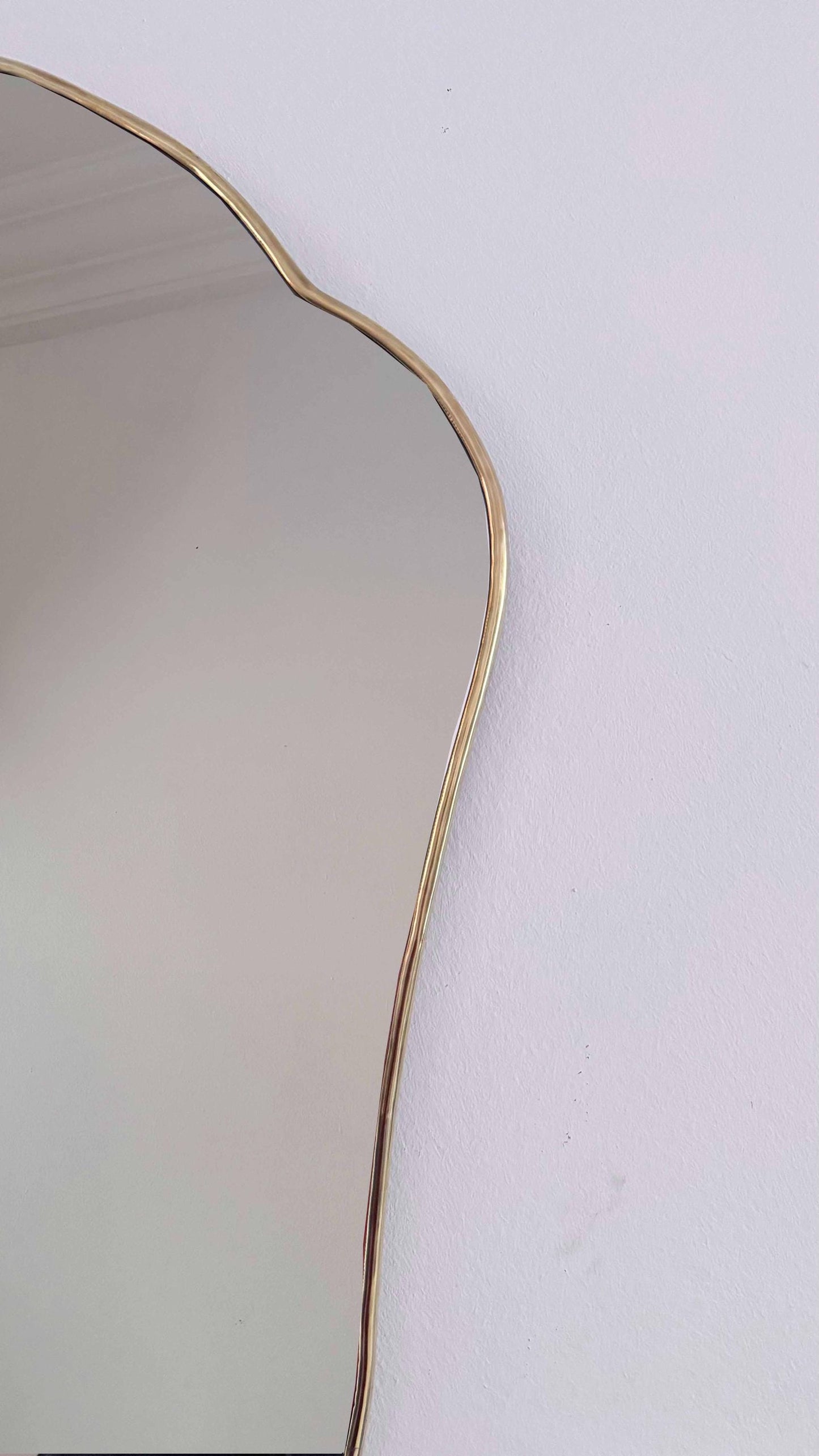 antique brass frame mirror on white wall