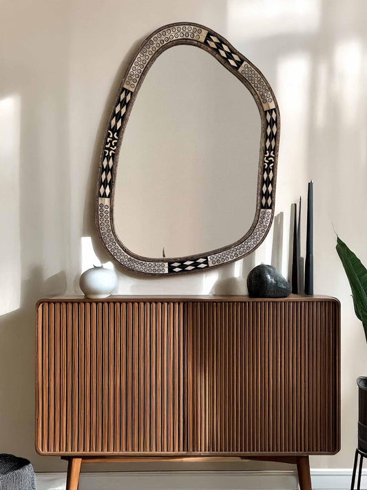 Asymmetrical Mirror above living room brown dresser