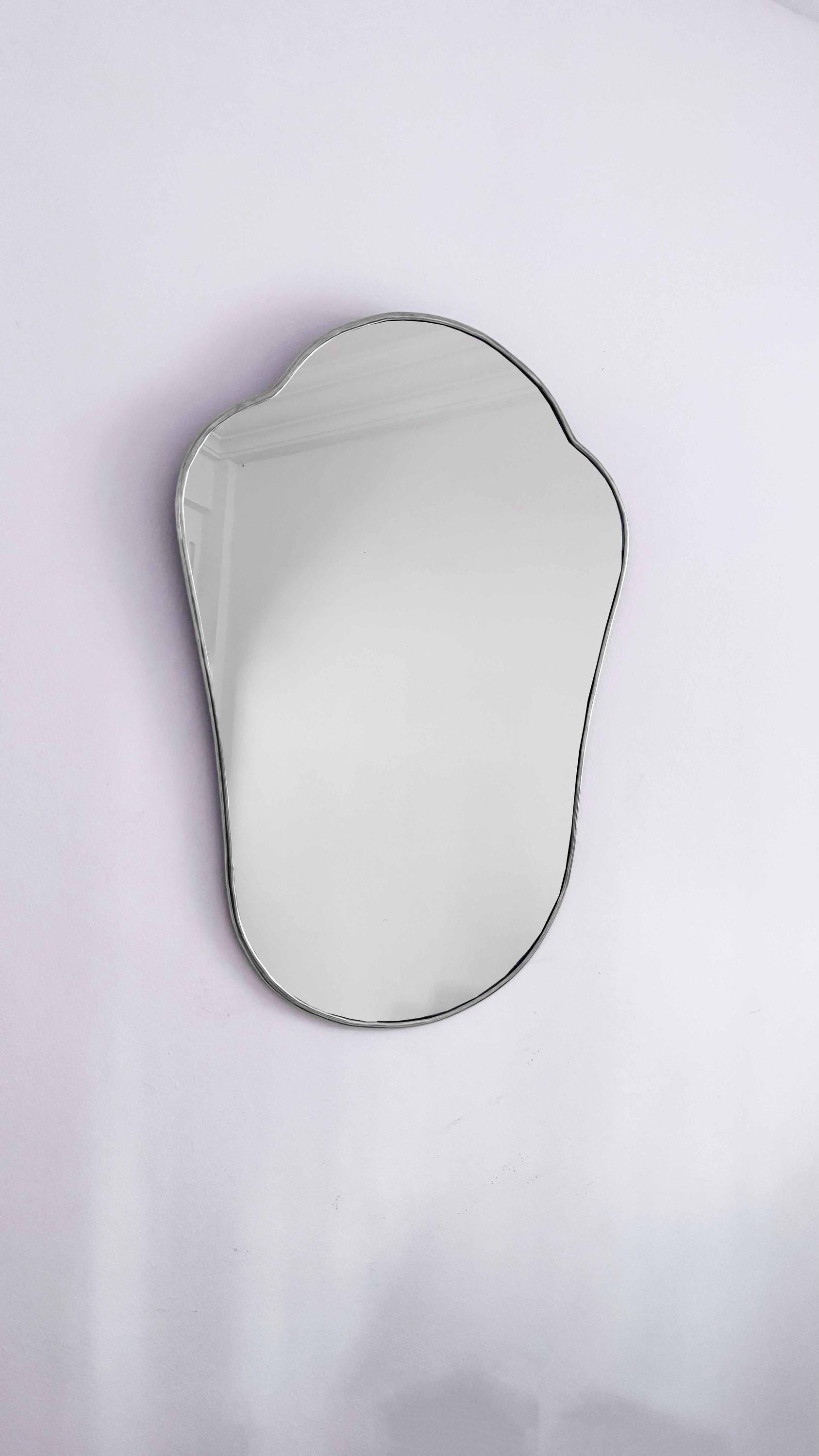 Silver mirror on white wall