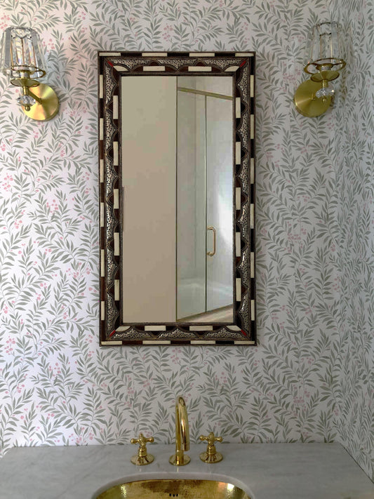 Rectangular brown bone inlay mirror above a brass sink