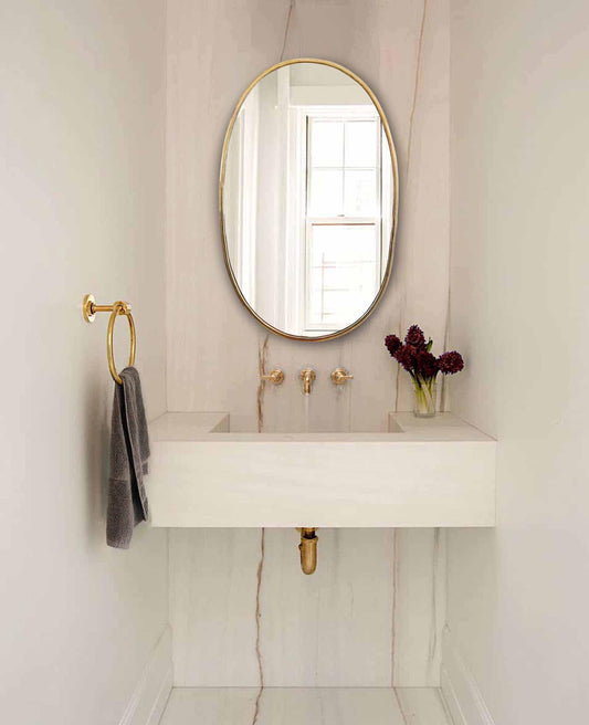 brass oval mirror in bathroom