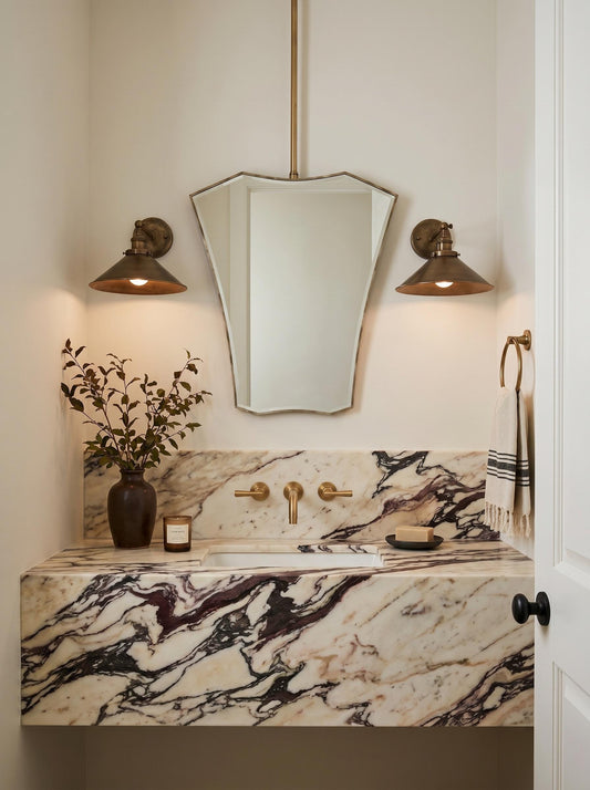 Geometric suspended brass mirror above marble vanity