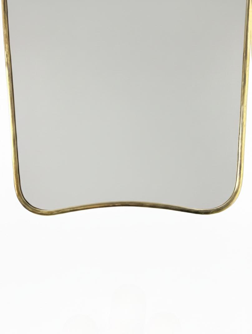 Curved brass mirror bottom edge detail