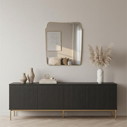 Unlacquered brass wall mirror above black console cabinet