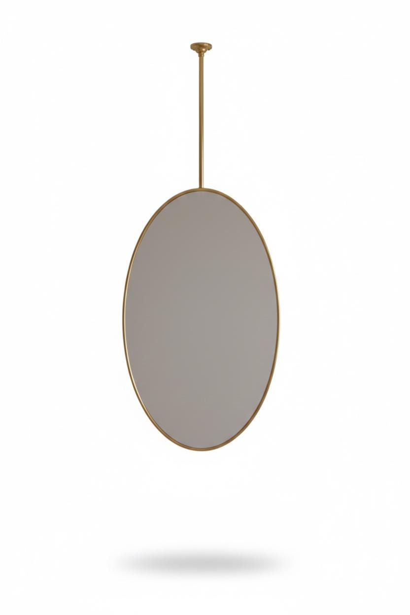 Oval brass suspended mirror in a white background