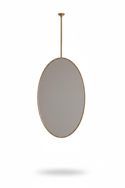Oval brass suspended mirror in a white background
