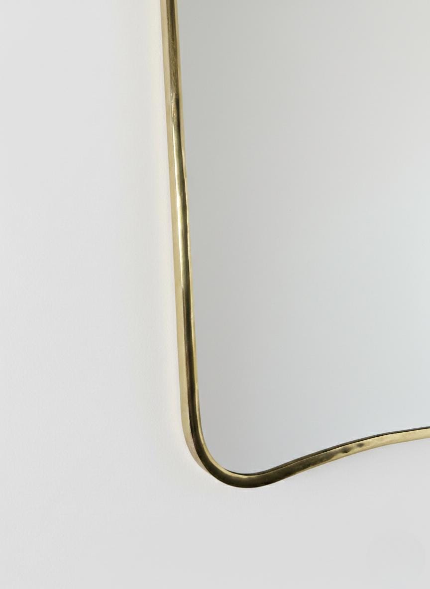 Close-up of curved brass mirror corner