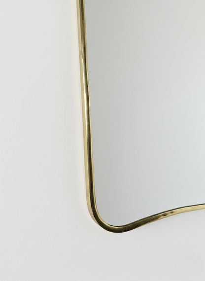 Close-up of curved brass mirror corner