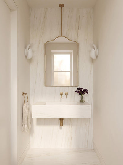 Modern brass vanity mirror above marble floating sink