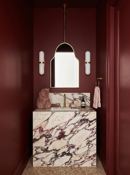 Modern brass arch mirror in burgundy powder room