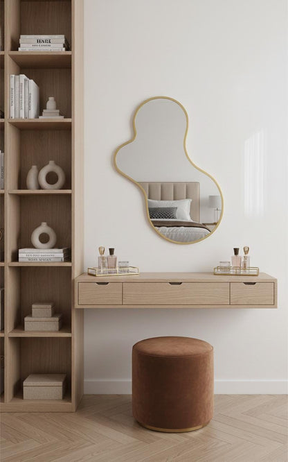 Irregular curved unlacquered brass wall mirror above vanity