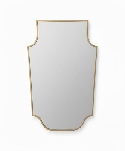 Shield-shaped brass mirror in a white background