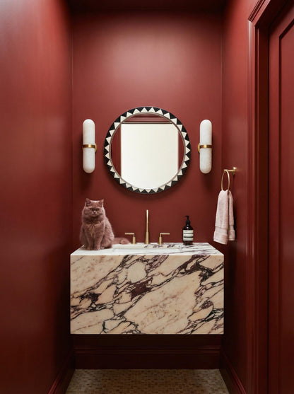 Black and white Moroccan round mirror in bold red bathroom interior