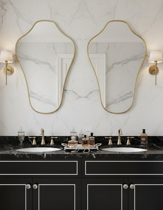 Asymmetrical brass bathroom mirror above double vanity