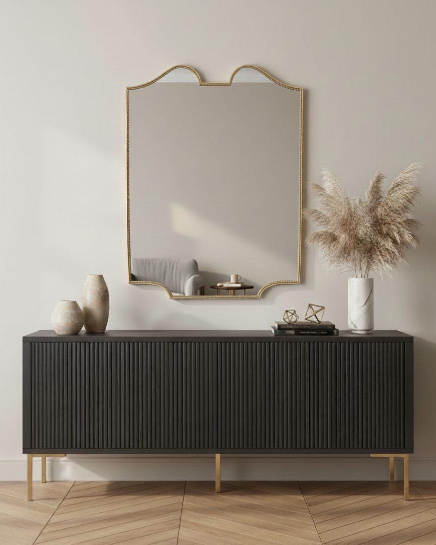 Curved scalloped brass mirror styled above black modern sideboard