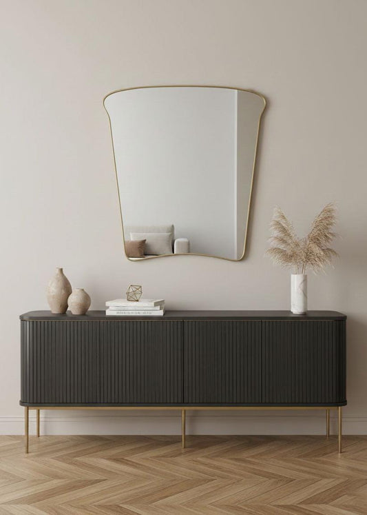 Modern brass mirror above black sideboard