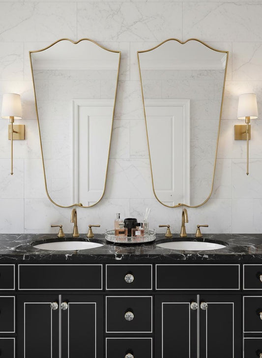 Pair of curved gold mirrors over double vanity