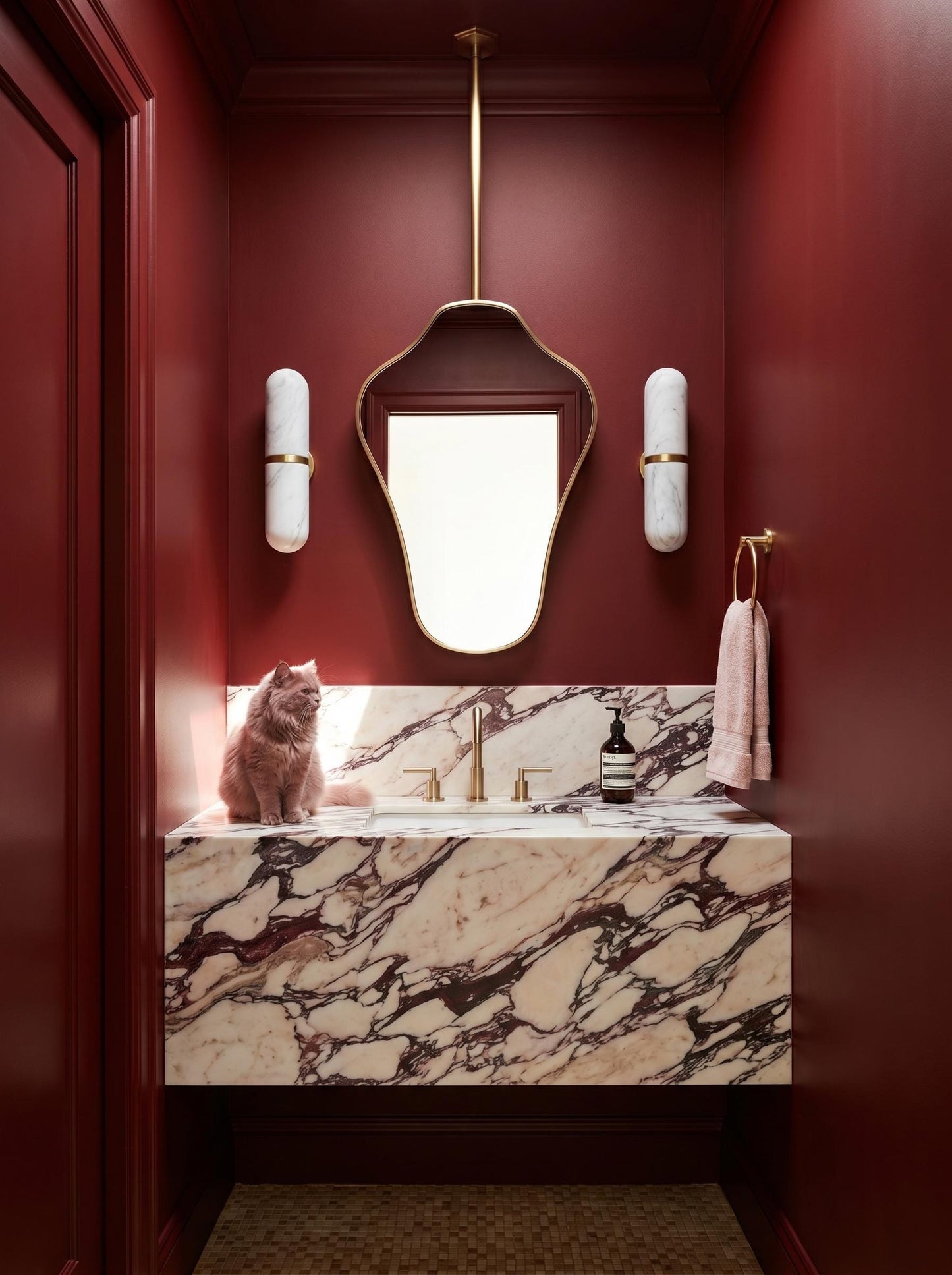 Suspended brass mirror in a moody red powder room