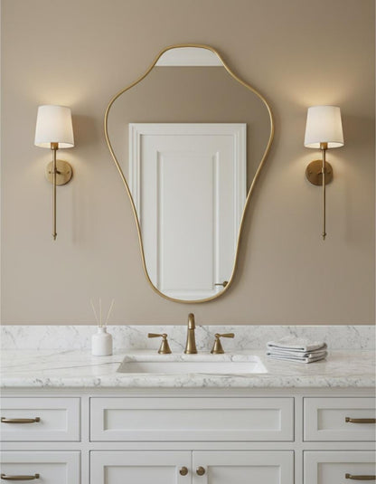 Organic modern brass mirror above white bathroom sink