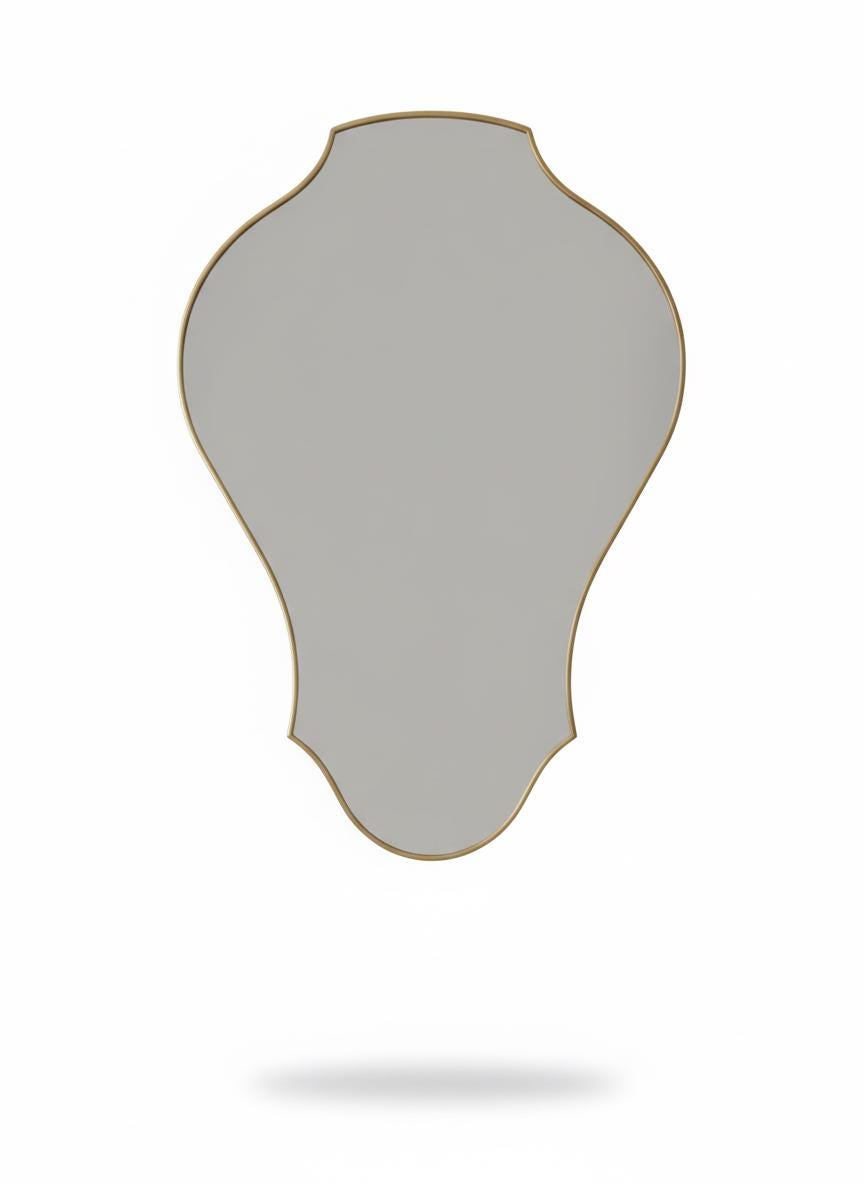 Curved sculptural brass wall mirror in a white background.
