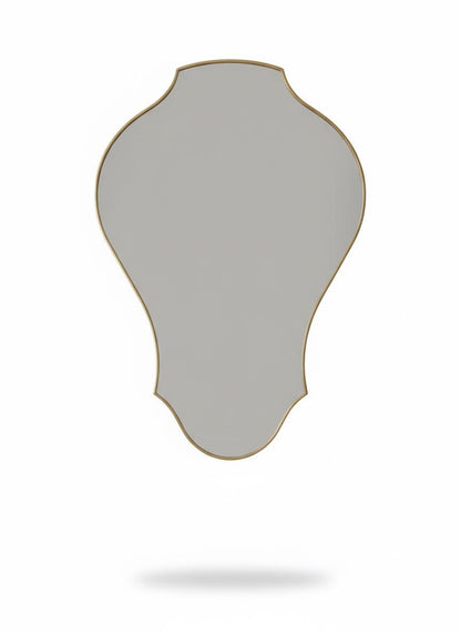 Curved sculptural brass wall mirror in a white background.