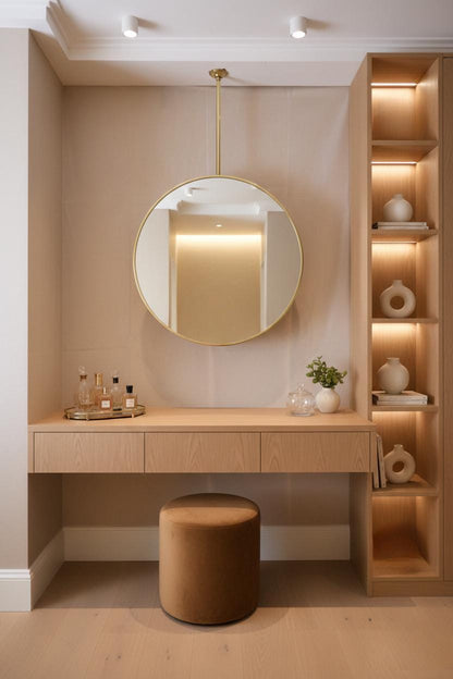 Round brass suspended mirror above wooden vanity