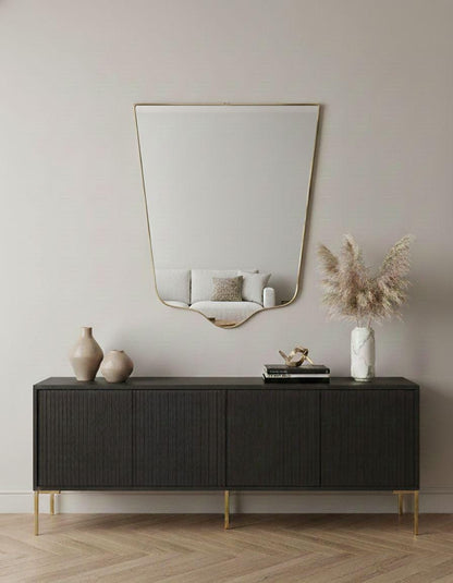 Handmade shield mirror over black sideboard