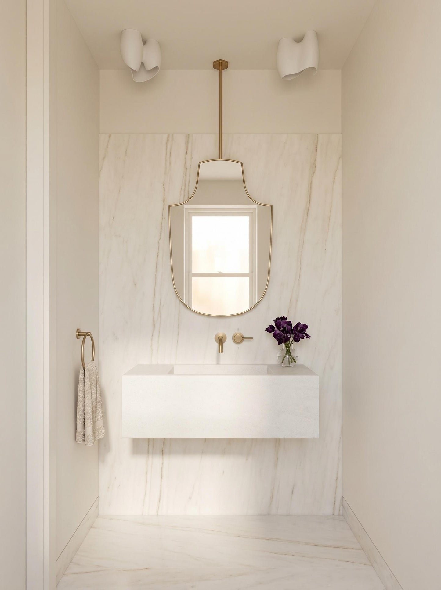 Ceiling-mounted brass mirror above floating white vanity in marble bathroom