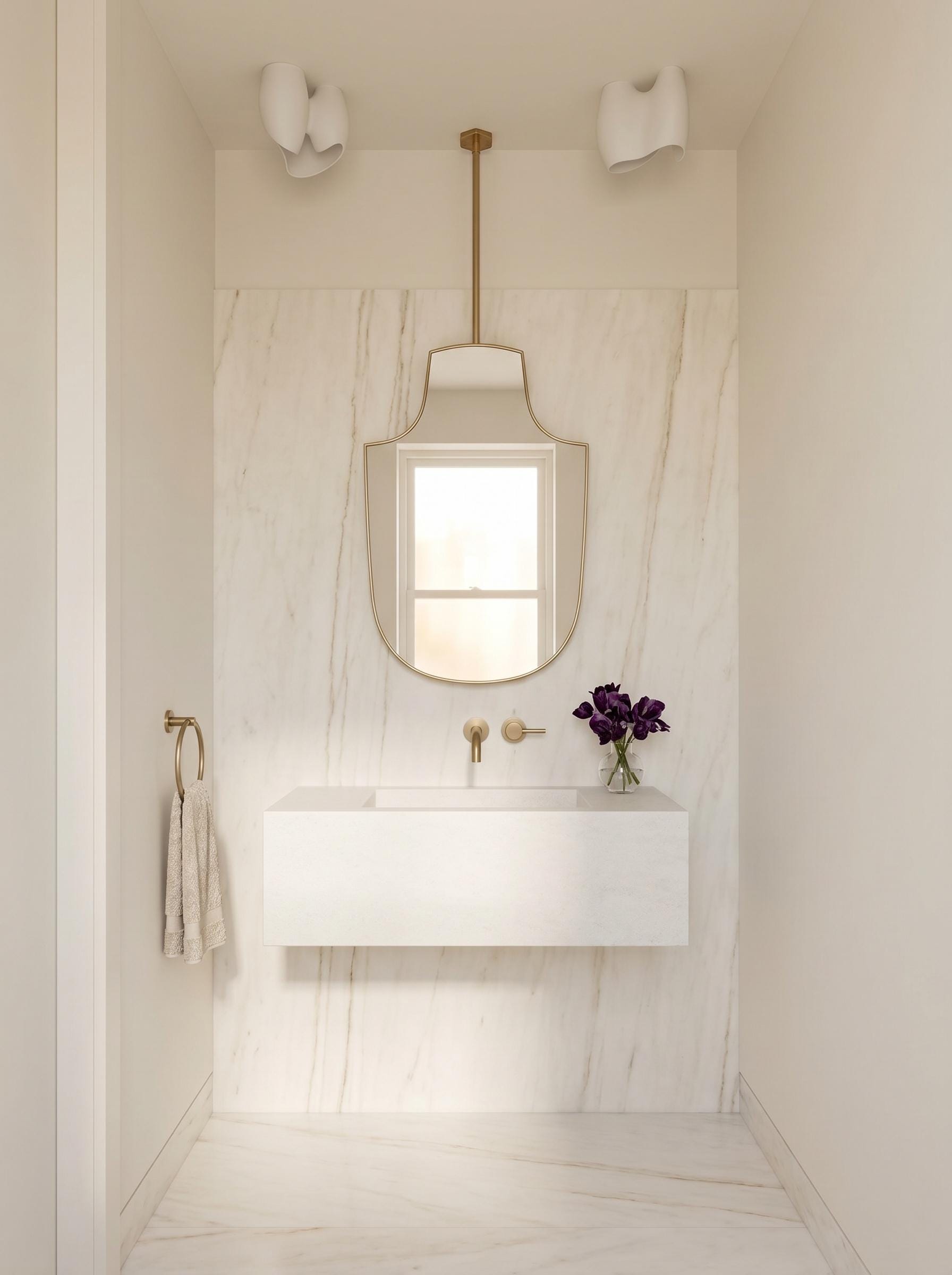 Ceiling-mounted brass mirror above floating white vanity in marble bathroom
