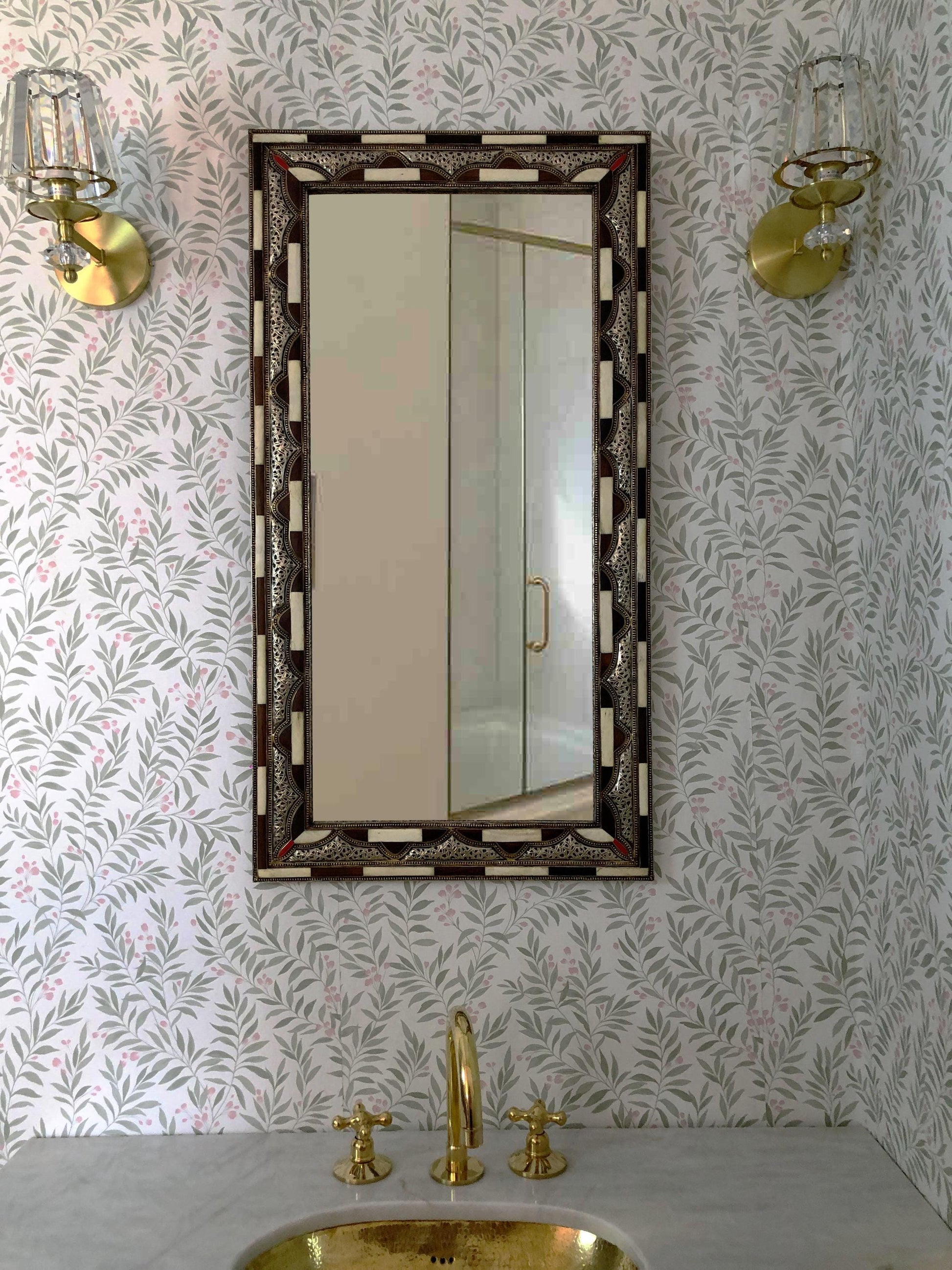 Rectangular brown bone inlay mirror above a brass sink