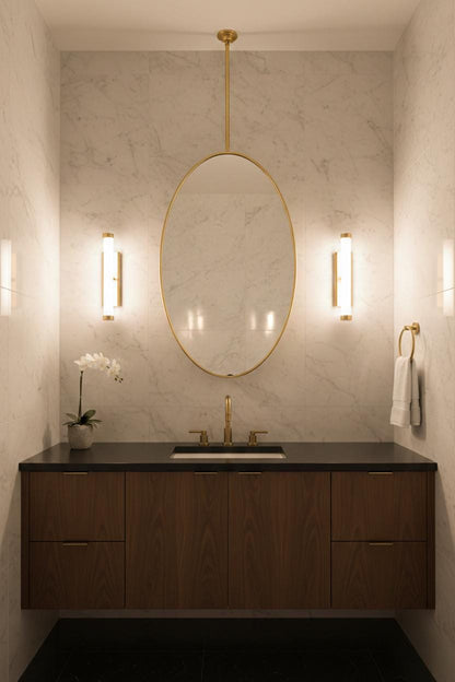 Oval brass hanging mirror in marble powder room