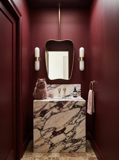 Handmade brass hanging mirror in luxury powder room