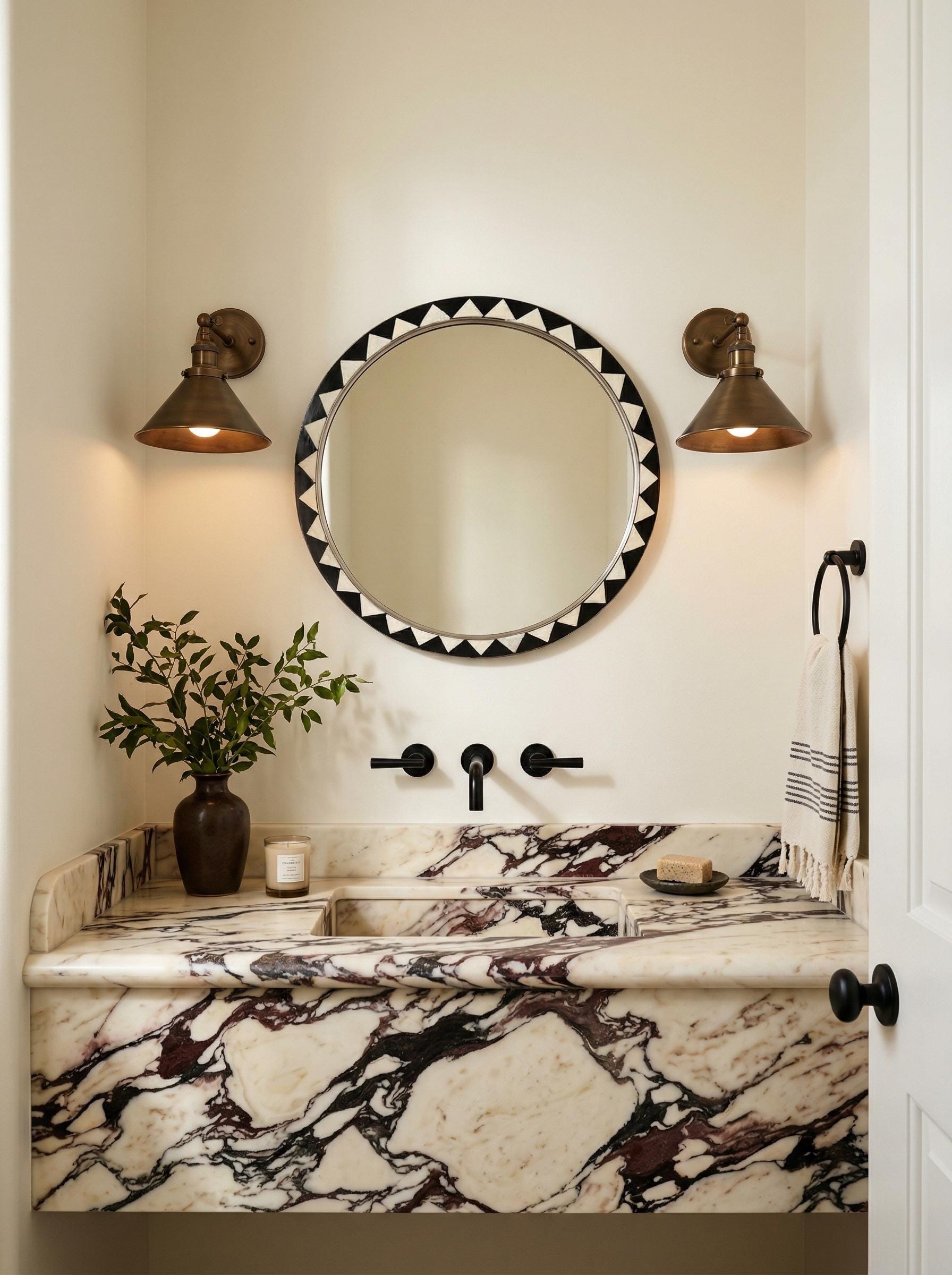 Moroccan round inlay mirror above marble sink with brass wall sconces