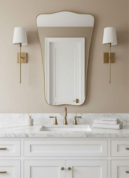 Shield-inspired brass bathroom mirror with wall sconces