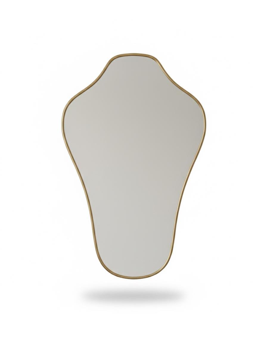 Irregular asymmetrical brass mirror in a white background