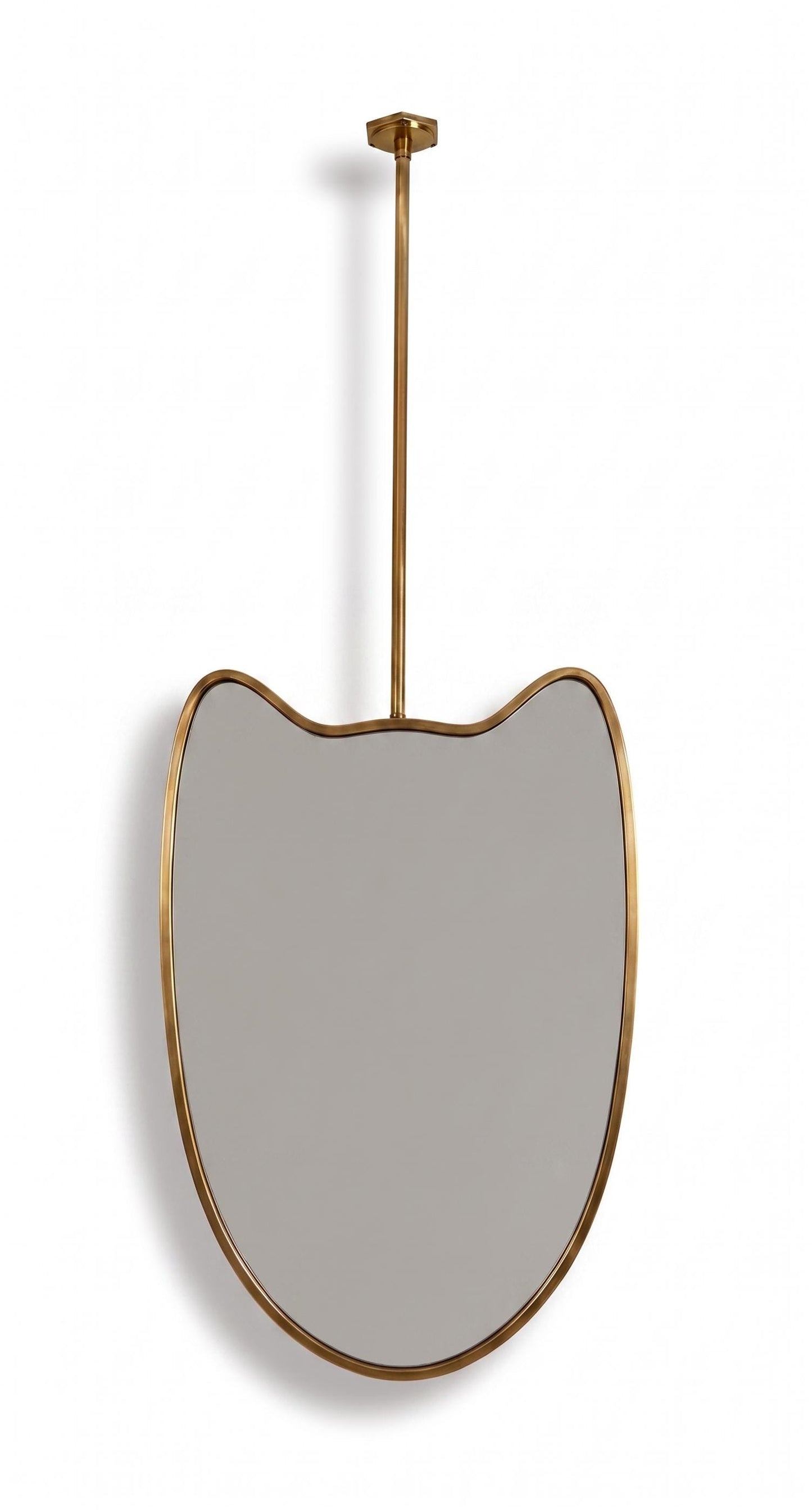 Suspended brass mirror with organic curved frame on white background