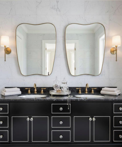 Modern irregular brass mirror in double sink bathroom