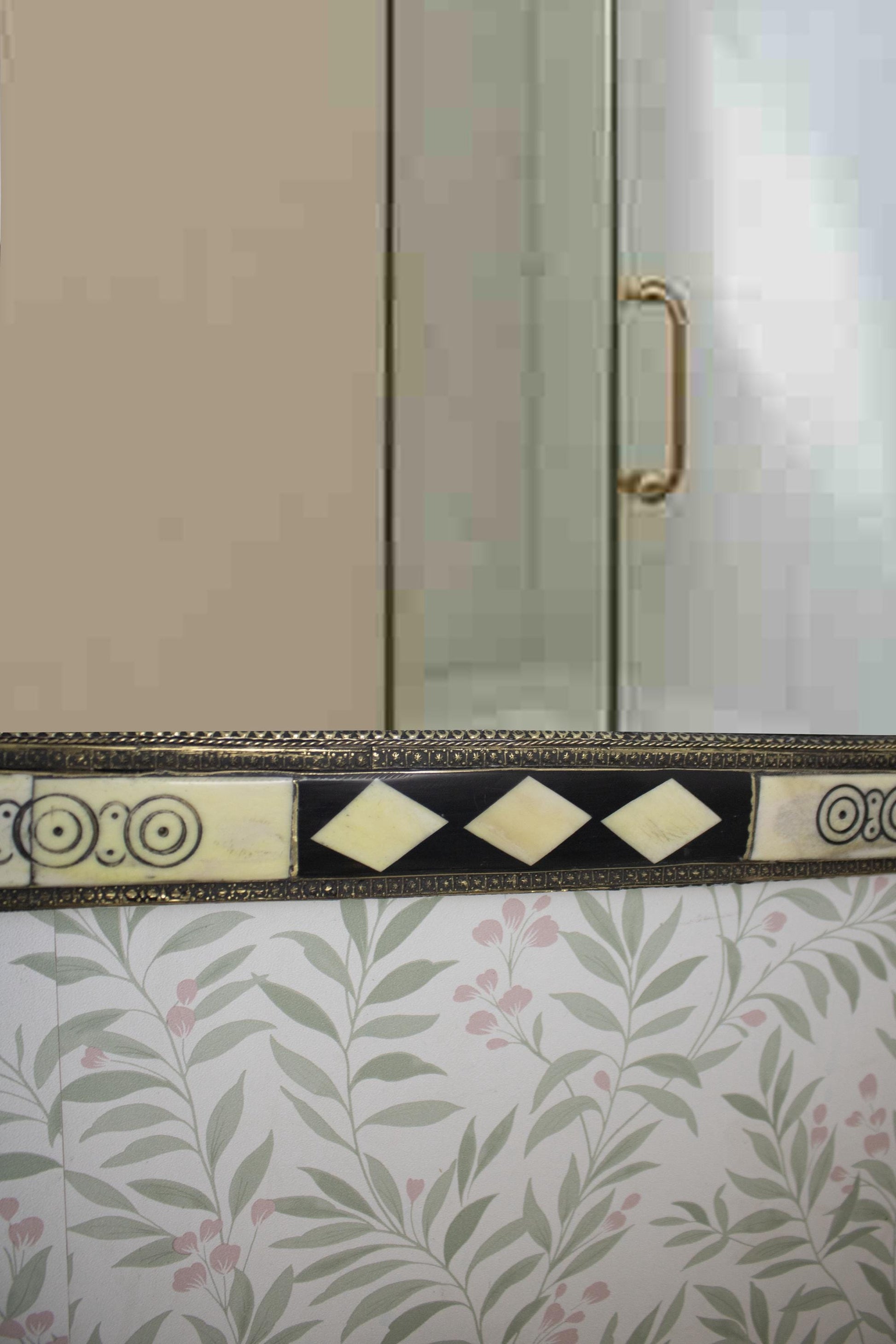 Close-up of the bottom center of the mirror showing diamond-shaped inlays.