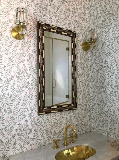 Elegant bathroom with brass fixtures and a brown bone inlay mirror.