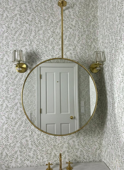 Suspended round brass bathroom mirror with wall sconces
