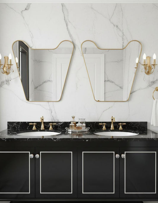 Irregular unlacquered brass bathroom mirror above double vanity