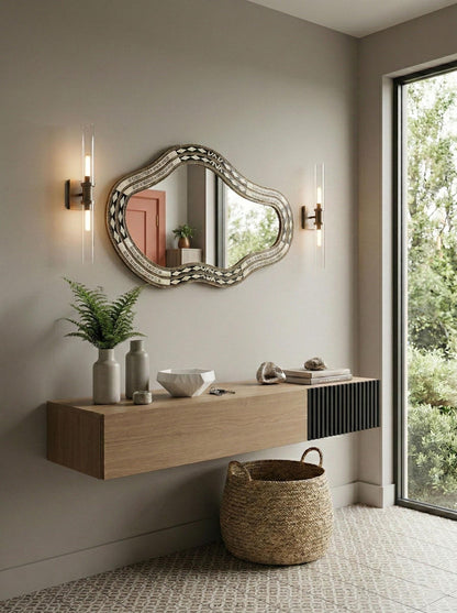 Freeform bone and brass mirror above floating wood console with wall sconces