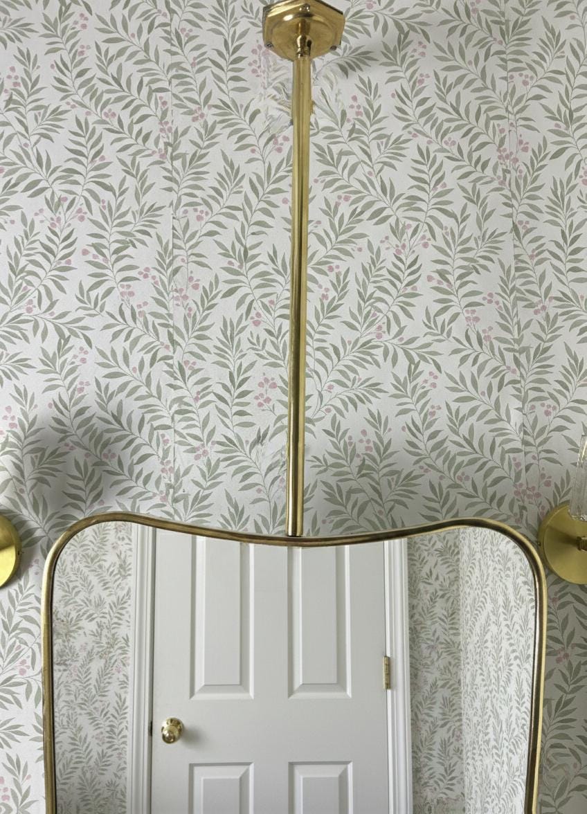 Suspended brass mirror with curved frame detail