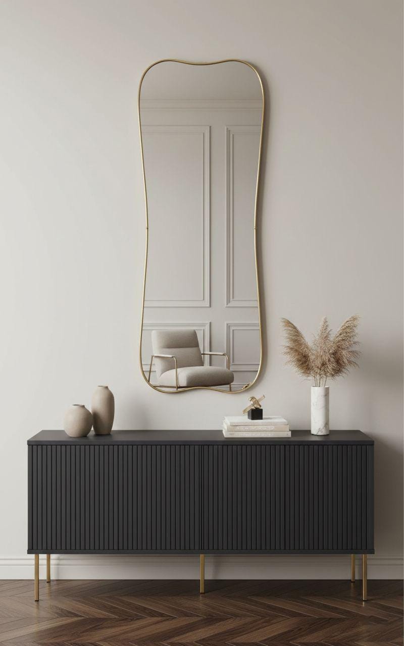 Wavy edge gold brass wall mirror above modern console