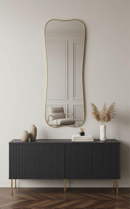 Wavy edge gold brass wall mirror above modern console