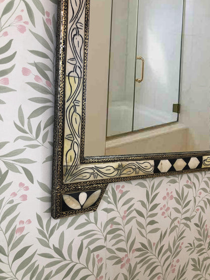 Close-up of the lower corner of a bone inlay mirror with floral pattern frame