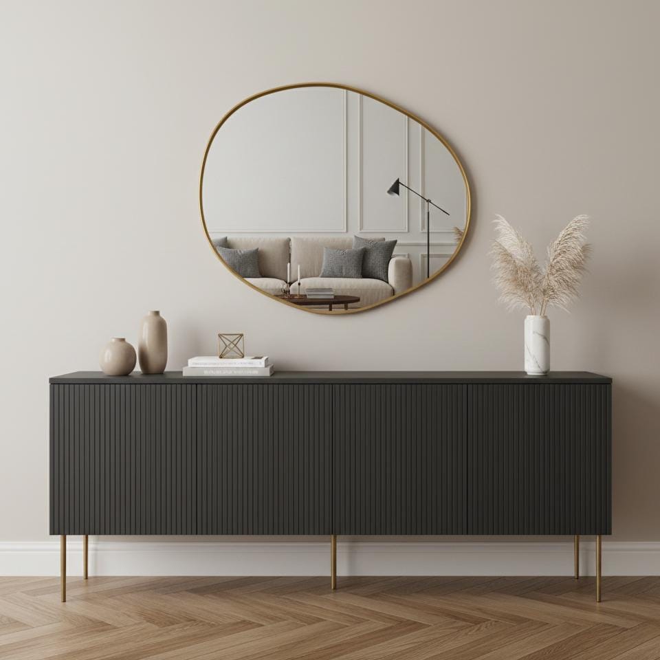 Organic round brass mirror over black console table