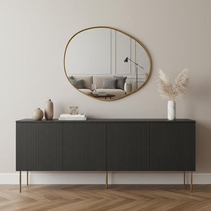 Organic round brass mirror over black console table